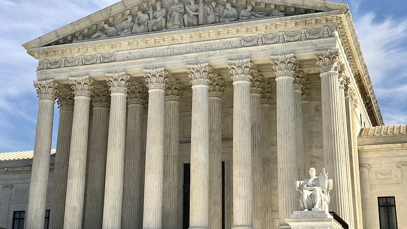A narrow set of marble steps rising between two stone columns toward a shadowed entrance.